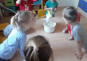 Dzieci obserwują ubijanie masła.